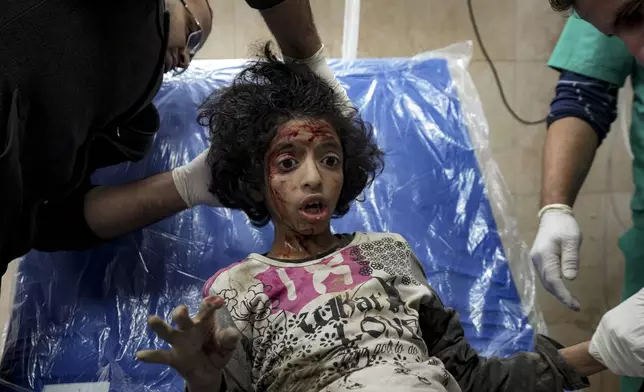 A Palestinian child wounded during the Israeli bombardment of the Gaza Strip receives treatment at the Al-Aqsa Hospital in Deir al-Balah, Thursday, Dec. 19, 2024. (AP Photo/Abdel Kareem Hana)