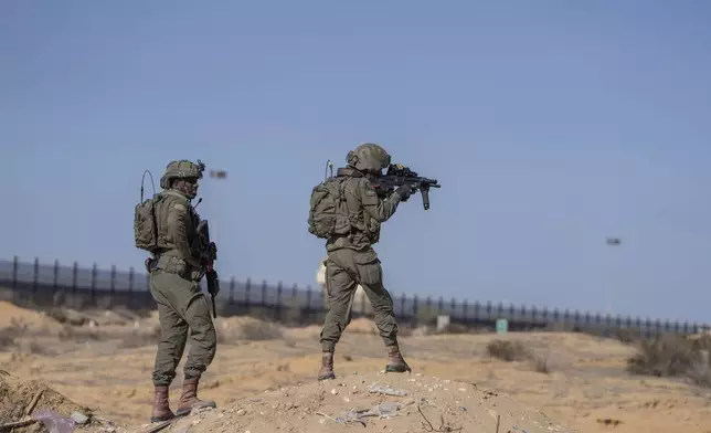 Israeli soldiers stand guard on the Palestinian side of the Kerem Shalom crossing as reporters tour the area in the Gaza Strip, Thursday, Dec. 19, 2024. (AP Photo/Ohad Zwigenberg)