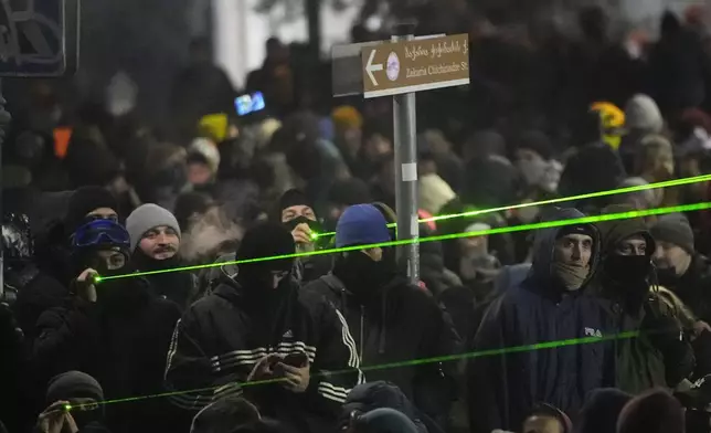 Demonstrators use lasers against the police during a rally outside the parliament building to protests against the government's decision to suspend negotiations on joining the European Union in Tbilisi, Georgia, early Thursday, Dec. 5, 2024. (AP Photo/Pavel Bednyakov)