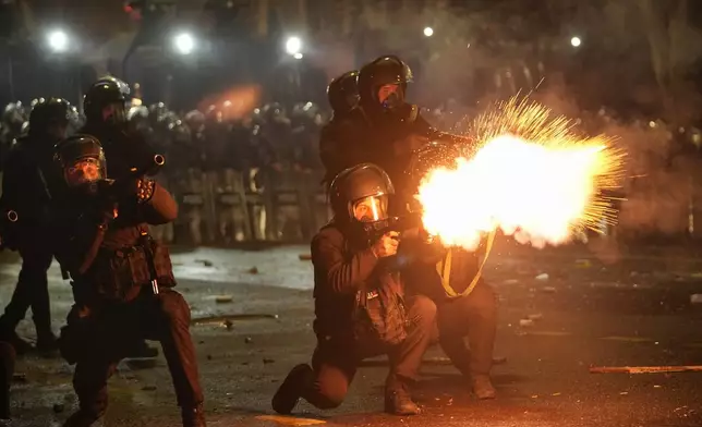 Police shoot tear gas towards demonstrators during a protest against the government's decision to suspend negotiations on joining the European Union in Tbilisi, Georgia, early Wednesday, Dec. 4, 2024. (AP Photo/Pavel Bednyakov)