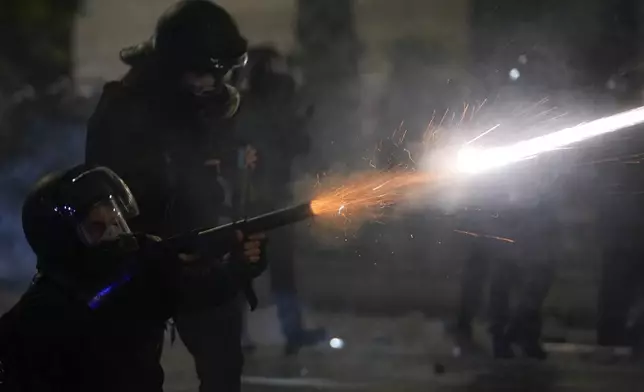 Police shoot tear gas towards demonstrators during a protest against the government's decision to suspend negotiations on joining the European Union in Tbilisi, Georgia, early Wednesday, Dec. 4, 2024. (AP Photo/Pavel Bednyakov)