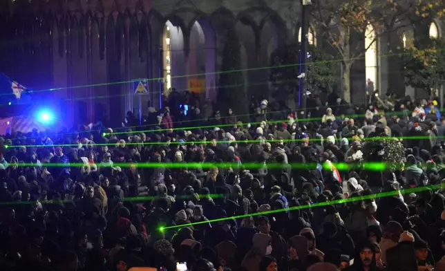 Demonstrators use lasers against the police during a rally outside the parliament building to protests against the government's decision to suspend negotiations on joining the European Union in Tbilisi, Georgia, on Wednesday, Dec. 4, 2024. (AP Photo/Pavel Bednyakov)
