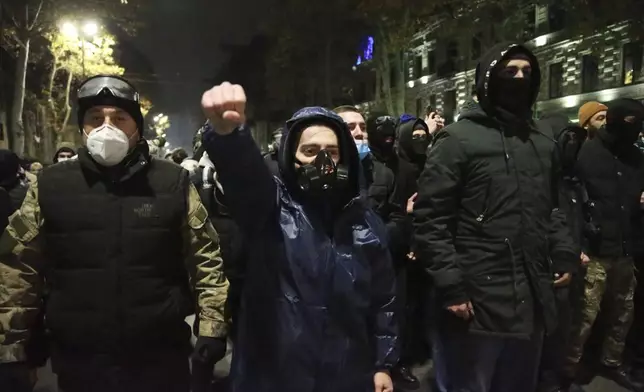 Demonstrators stand in front of the police during a rally to protest against the government's decision to suspend negotiations on joining the European Union in Tbilisi, Georgia, early Wednesday, Dec. 4, 2024. (AP Photo/Zurab Tsertsvadze)