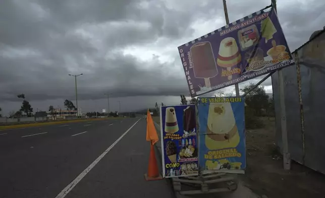 Signs advertise Salcedo's creamy popsicles along the Pan-American highway, in Latacunga, Ecuador, Thursday, Nov. 28, 2024, amid a wave of power outages, triggered by a prolonged dry spell. (AP Photo/Dolores Ochoa)