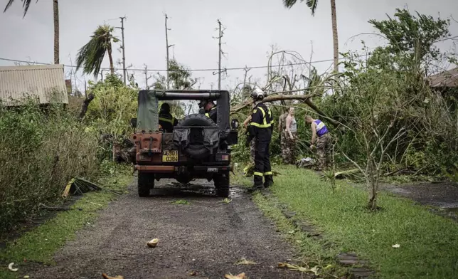 This photo provided Sunday Dec.15, 2024 by the Civil Security shows soldiers and rescue workers clearing a street in the French territory of Mayotte in the Indian Ocean, after Cyclone Chido caused extensive damage with reports of several fatalities, Saturday Dec.14, 2024. (UIISC7/Securite civile via AP)