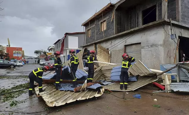 This photo provided Sunday Dec.15, 2024 by the Civil Security shows rescue workers clearing an area in the French territory of Mayotte in the Indian Ocean, after Cyclone Chido caused extensive damage with reports of several fatalities, Saturday Dec.14, 2024. (UIISC7/Securite civile via AP)