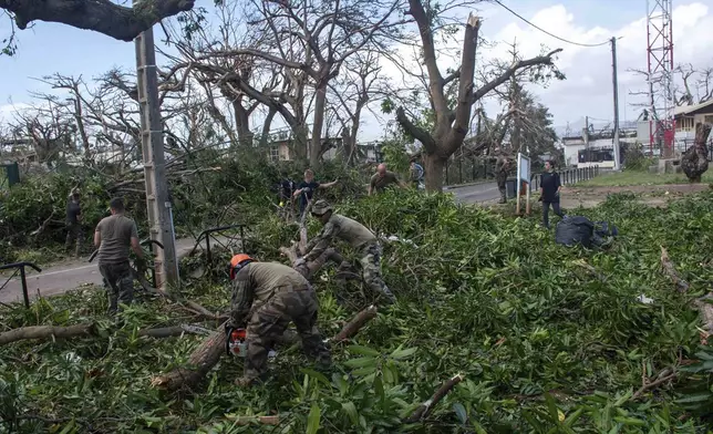 This photo provided Sunday Dec.15, 2024 by the French Army shows soldiers removing fallen trees in the French territory of Mayotte in the Indian Ocean, after Cyclone Chido caused extensive damage with reports of several fatalities. (Etat Major des Armées via AP)