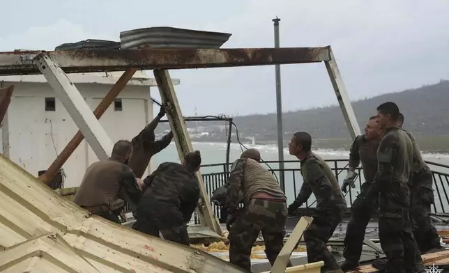 This photo provided Sunday Dec.15, 2024 by the French Army shows soldiers at work to restore a building in the French territory of Mayotte in the Indian Ocean, after Cyclone Chido caused extensive damage with reports of several fatalities, Saturday Dec.14, 2024. (Etat Major des Armées via AP)