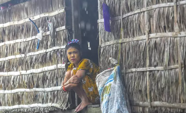 Tepan Klathale sits on her house in Moken village at Surin Islands in Phang Nga Province, Thailand, on a rainy Thursday, Dec. 12, 2024. (AP Photo/Sakchai Lalit)