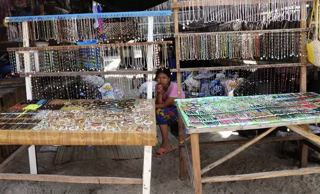 York Klathale waits for customers to buy souvenirs at Moken village at Surin Islands in Phang Nga Province, Thailand, Wednesday, Dec. 11, 2024. (AP Photo/Sakchai Lalit)