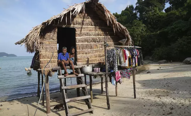 Jepen Klathale and his wife Boomkoyoung Klathale sit on their house in Moken village at Surin Islands in Phang Nga Province, Thailand, Wednesday, Dec. 11, 2024. (AP Photo/Sakchai Lalit)