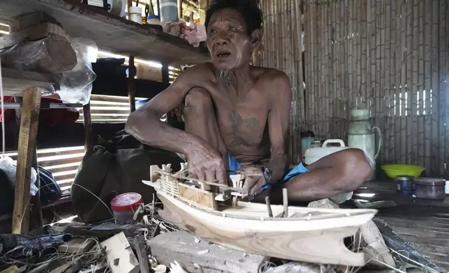 Tat Klathale makes a Kabang boat model for tourists to buy at Surin Islands in Phang Nga Province, Thailand, Thursday, Dec. 12, 2024. (AP Photo/Sakchai Lalit)