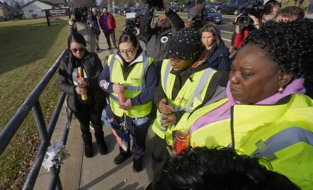 A group says a prayer outside the Abundant Life Christian School Tuesday, Dec. 17, 2024 in Madison, Wis., following a shooting on Monday. (AP Photo/Morry Gash)