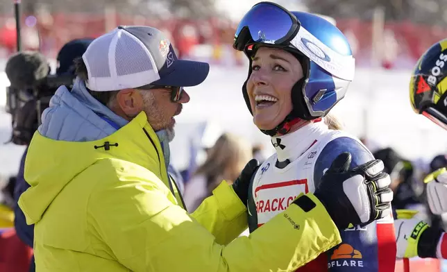 United States' Lindsey Vonn, right, is congratulated by Red Bull Head of Athletes Special Projects Patrick Riml after she competed in an alpine ski, women's World Cup super G, in St. Moritz, Switzerland, Saturday, Dec. 21, 2024. (AP Photo/Giovanni Auletta)