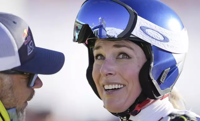 United States' Lindsey Vonn, right, smiles after completing an alpine ski, women's World Cup super G, in St. Moritz, Switzerland, Saturday, Dec. 21, 2024. (Til Buergy/Keystone via AP)