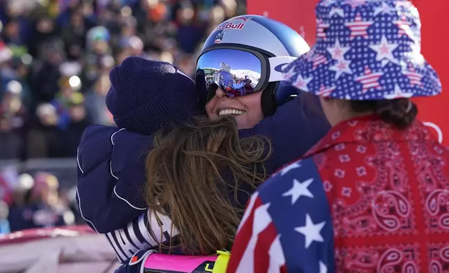 Italy's Sofia Goggia, left, hugs United States' Lindsey Vonn after Vonn competed in an alpine ski, women's World Cup super G, in St. Moritz, Switzerland, Saturday, Dec. 21, 2024. (AP Photo/Giovanni Auletta)