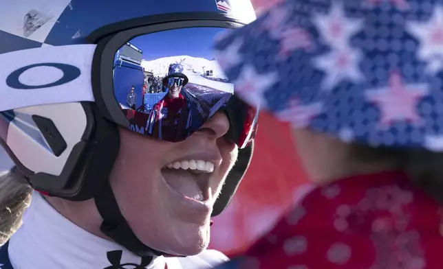 United States' Lindsey Vonn, right, smiles after completing an alpine ski, women's World Cup super G, in St. Moritz, Switzerland, Saturday, Dec. 21, 2024. (Til Buergy/Keystone via AP)