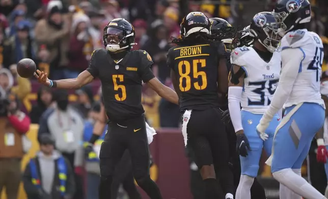 Washington Commanders quarterback Jayden Daniels (5) celebrates his touchdown during the first half of an NFL football game against the Tennessee Titans, Sunday, Dec. 1, 2024, in Landover, Md. (AP Photo/Matt Slocum)