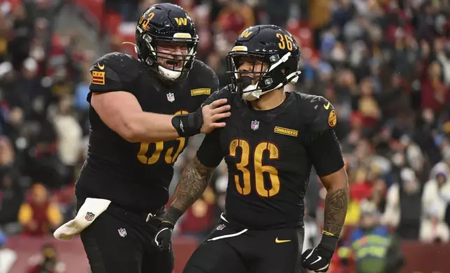 Washington Commanders running back Chris Rodriguez Jr. (36) celebrates his touchdown with center Tyler Biadasz (63) during the second half of an NFL football game against the Tennessee Titans, Sunday, Dec. 1, 2024, in Landover, Md. (AP Photo/Steve Ruark)