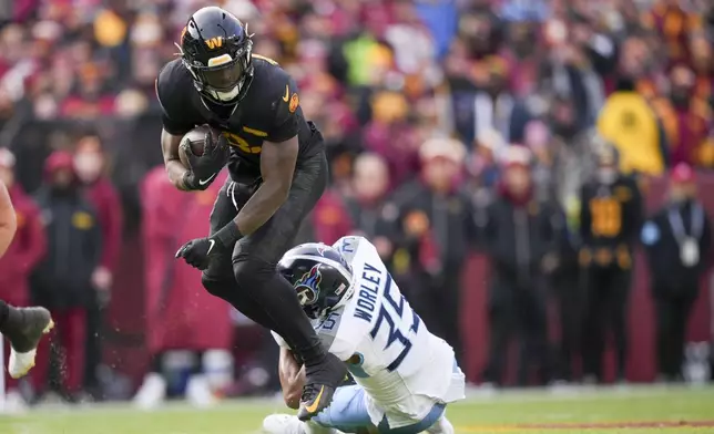 Washington Commanders running back Brian Robinson Jr. (8) runs the ball past Tennessee Titans cornerback Daryl Worley (35) during the first half of an NFL football game Sunday, Dec. 1, 2024, in Landover, Md. (AP Photo/Matt Slocum)