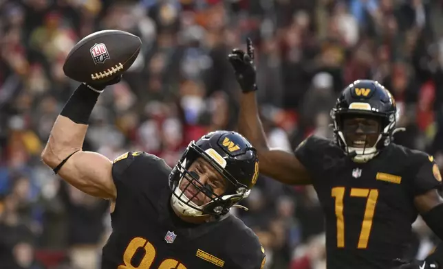 Washington Commanders tight end Zach Ertz, left, celebrates his touchdown during the second half of an NFL football game against the Tennessee Titans, Sunday, Dec. 1, 2024, in Landover, Md. (AP Photo/Steve Ruark)