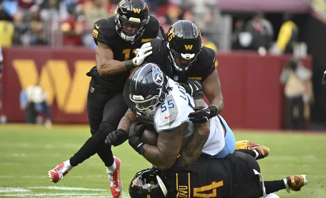 Tennessee Titans offensive tackle JC Latham (55) is tackled after catching a tipped pass by Washington Commanders safety Jeremy Chinn (11), defensive tackle Jer'Zhan Newton (95) and linebacker Frankie Luvu (4) during the first half of an NFL football game Sunday, Dec. 1, 2024, in Landover, Md. (AP Photo/Steve Ruark)