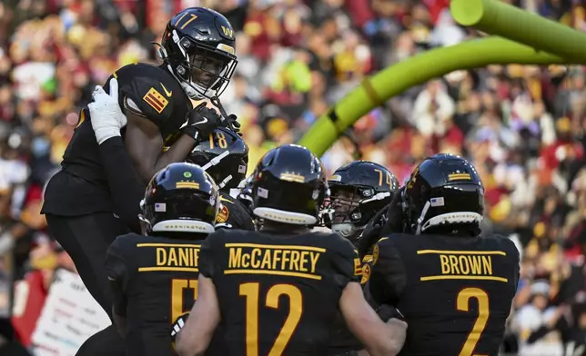 Washington Commanders wide receiver Terry McLaurin (17) celebrates his touchdown with teammates during the first half of an NFL football game against the Tennessee Titans, Sunday, Dec. 1, 2024, in Landover, Md. (AP Photo/Steve Ruark)