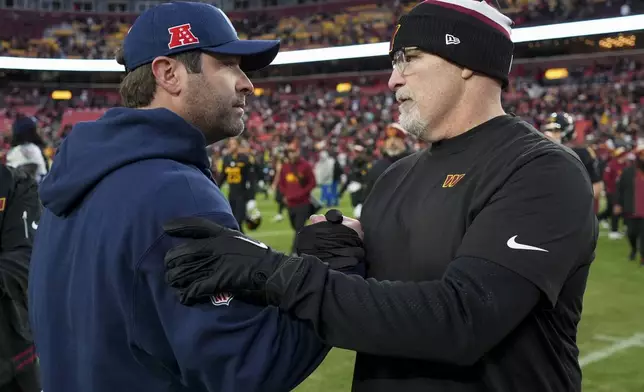 Tennessee Titans head coach Brian Callahan and Washington Commanders head coach Dan Quinn meet on the field after an NFL football game Sunday, Dec. 1, 2024, in Landover, Md. The Commanders won 42-19. (AP Photo/Matt Slocum)