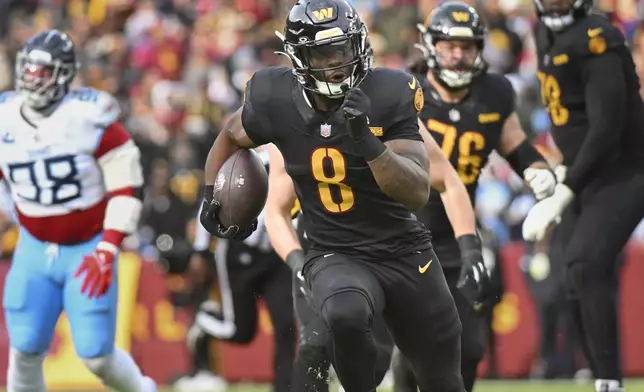 Washington Commanders running back Brian Robinson Jr. (8) runs the ball to score a touchdown during the first half of an NFL football game against the Tennessee Titans, Sunday, Dec. 1, 2024, in Landover, Md. (AP Photo/Steve Ruark)