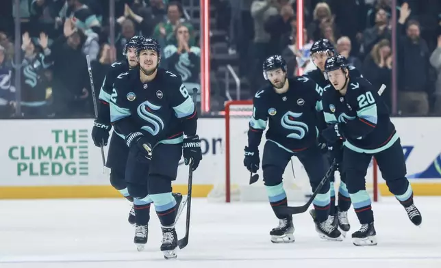 Seattle Kraken defenseman Brandon Montour, left, skates away after scoring a goal during the first period of an NHL hockey game against the Tampa Bay Lightning Saturday, Dec. 14, 2024, in Seattle. (AP Photo/Maddy Grassy)