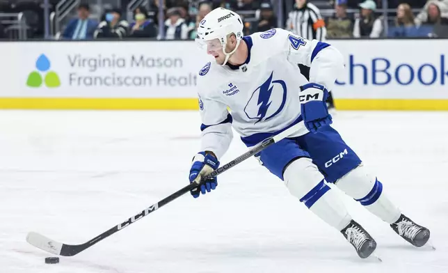 Tampa Bay Lightning defenseman Darren Raddysh skates with the puck during the second period of an NHL hockey game against the against the Seattle Kraken Saturday, Dec. 14, 2024, in Seattle. (AP Photo/Maddy Grassy)