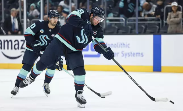 Seattle Kraken defenseman Vince Dunn shoots the puck during warmups before an NHL hockey game against the Tampa Bay Lightning Saturday, Dec. 14, 2024, in Seattle. (AP Photo/Maddy Grassy)