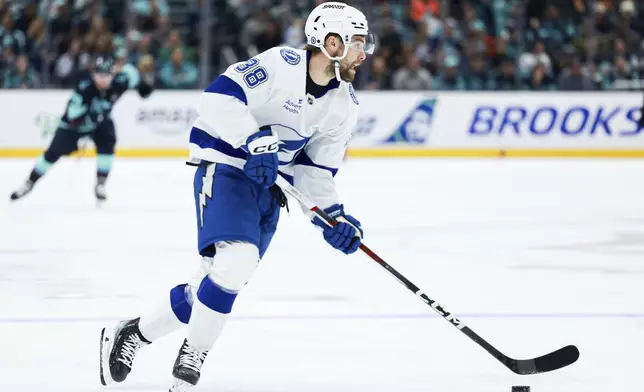 Tampa Bay Lightning left wing Brandon Hagel skates with the puck during the third period of an NHL hockey game against the Seattle Kraken Saturday, Dec. 14, 2024, in Seattle. (AP Photo/Maddy Grassy)