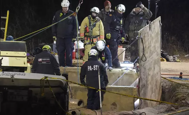 Rescue workers search through the night in a sinkhole for Elizabeth Pollard, who disappeared while looking for her cat, in Marguerite, Pa., Tuesday, Dec. 3, 2024. (AP Photo/Gene J. Puskar)