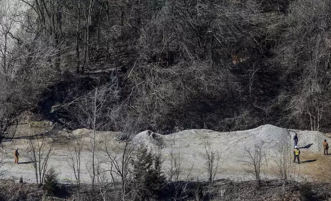 FILE - Officials stand on one edge of a giant sinkhole on the property of the Louisville Zoo, Wednesday, March 6, 2019, in Louisville, Ky. (Jeff Faughender/Courier Journal via AP, File)