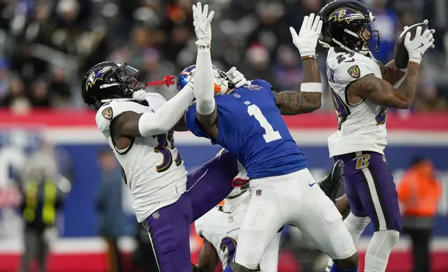 Baltimore Ravens safety Ar'Darius Washington (29) intercepts a pass intended for New York Giants wide receiver Malik Nabers (1) defended by Baltimore Ravens cornerback Desmond King II (35) during the fourth quarter of an NFL football game, Sunday, Dec. 15, 2024, in East Rutherford, N.J. (AP Photo/Seth Wenig)