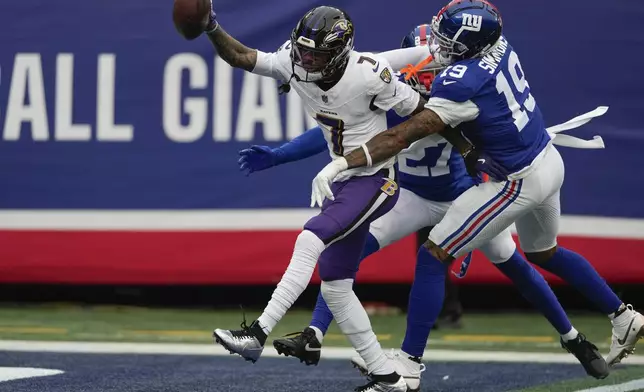 Baltimore Ravens wide receiver Rashod Bateman (7) crosses the goal line for a touchdown against New York Giants linebacker Isaiah Simmons (19) and safety Jason Pinnock (27) during the second quarter of an NFL football game, Sunday, Dec. 15, 2024, in East Rutherford, N.J. (AP Photo/Seth Wenig)