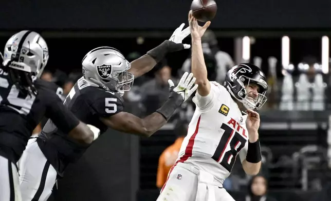 Atlanta Falcons quarterback Kirk Cousins (18) throws under pressure from Las Vegas Raiders linebacker Divine Deablo (5) during the first half of an NFL football game, Monday, Dec. 16, 2024, in Las Vegas. (AP Photo/David Becker)