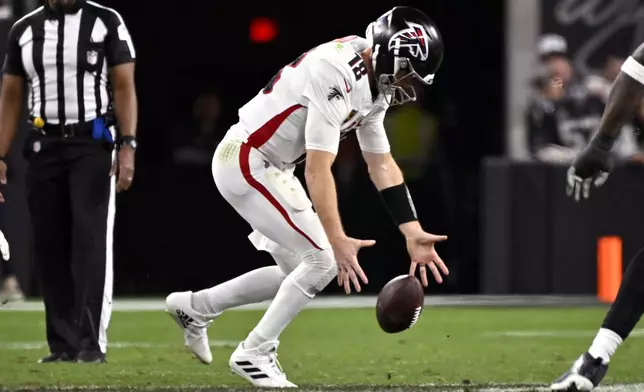 Atlanta Falcons quarterback Kirk Cousins recovers a bad snap during the second half of an NFL football game against the Las Vegas Raiders, Monday, Dec. 16, 2024, in Las Vegas. (AP Photo/David Becker)