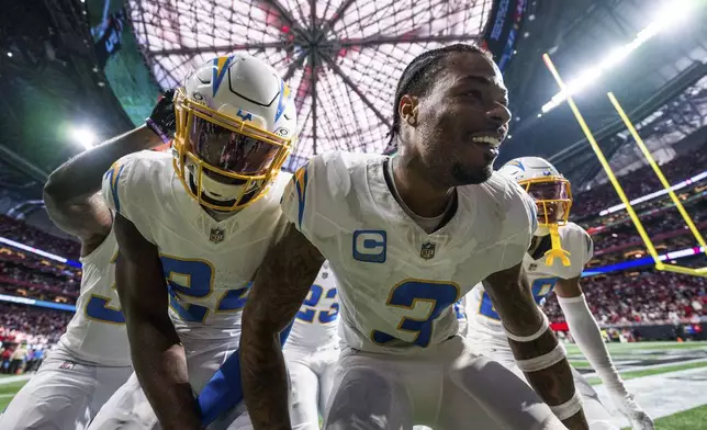 Los Angeles Chargers safety Derwin James Jr. (3) celebrates with teammates after an interception during the second half of an NFL football game against the Atlanta Falcons on Sunday, Dec. 1, 2024 in Atlanta. (AP Photo/Danny Karnik)