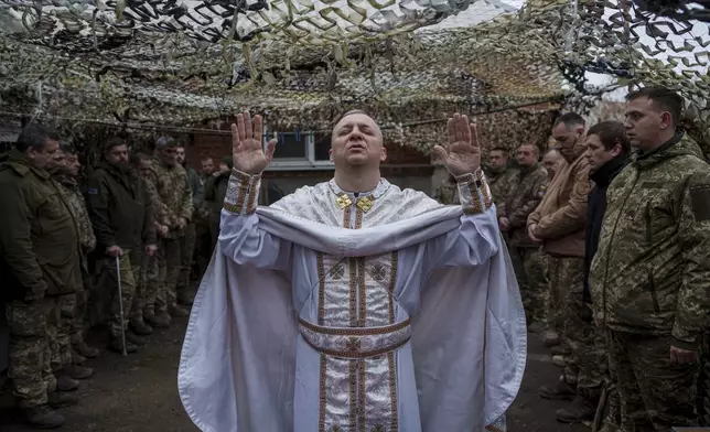 Military chaplain Yurii of the 24th Mechanized Brigade holds a church service for an infantry unit during Christmas near the frontline town of Chasiv Yar, Donetsk region, Ukraine, Wednesday Dec. 25, 2024. (AP Photo/Evgeniy Maloletka)