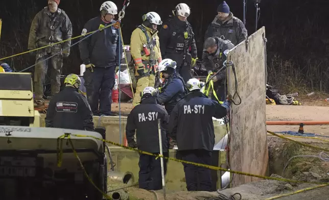 Rescue workers search through the night in a sinkhole for Elizabeth Pollard, who disappeared while looking for her cat, in Marguerite, Pa., Tuesday, Dec. 3, 2024. (AP Photo/Gene J. Puskar)