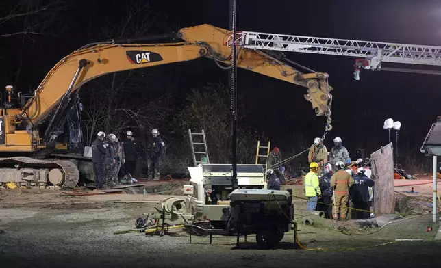 Rescue workers search through the night in a sinkhole for Elizabeth Pollard, who disappeared while looking for her cat, in Marguerite, Pa., Tuesday, Dec. 3, 2024. (AP Photo/Gene J. Puskar)