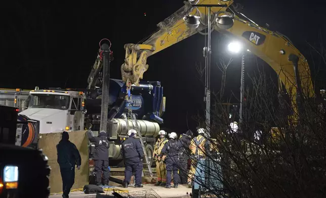 Rescue workers search through the night in a sinkhole for Elizabeth Pollard, who disappeared while looking for her cat, in Marguerite, Pa., Tuesday, Dec. 3, 2024. (AP Photo/Gene J. Puskar)