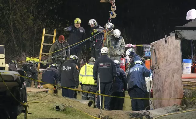 Rescue workers search through the night in a sinkhole for Elizabeth Pollard, who disappeared while looking for her cat, in Marguerite, Pa., Tuesday, Dec. 3, 2024. (AP Photo/Gene J. Puskar)