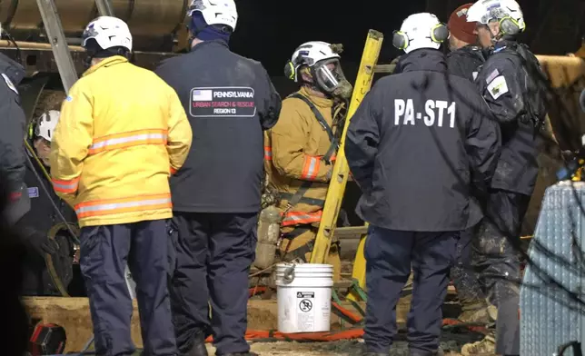 Rescue workers search through the night in a sinkhole for Elizabeth Pollard, who disappeared while looking for her cat, in Marguerite, Pa., Tuesday, Dec. 3, 2024. (AP Photo/Gene J. Puskar)