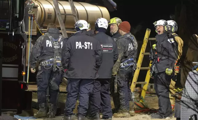 Rescue workers search through the night in a sinkhole for Elizabeth Pollard, who disappeared while looking for her cat, in Marguerite, Pa., Tuesday, Dec. 3, 2024. (AP Photo/Gene J. Puskar)