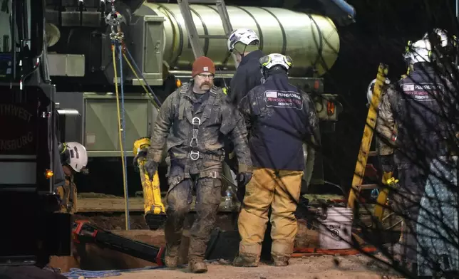 Rescue workers search through the night in a sinkhole for Elizabeth Pollard, who disappeared while looking for her cat, in Marguerite, Pa., Tuesday, Dec. 3, 2024. (AP Photo/Gene J. Puskar)