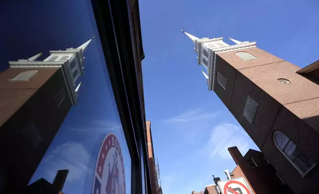 Old North Church, right, is reflected in a storefront window, left, Wednesday, Dec. 18, 2024, in Boston. (AP Photo/Steven Senne)