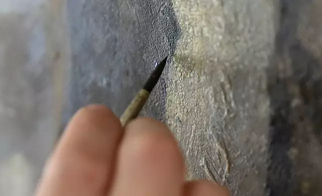 Conservator Corrine Long, of Dover, N.H., restores nearly 300-year-old painted angels on walls of Old North Church, Wednesday, Dec. 18, 2024, in Boston. (AP Photo/Steven Senne)